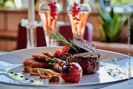 Ein Pfeffersteak mit Beilagen auf einem Teller serviert.